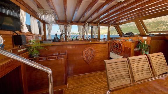 Interior of the Gulet Linda with stylish wooden furnishings and a steering wheel.